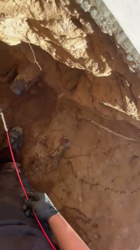 A sewer camera line fed into a curbside excavation, live job footage.