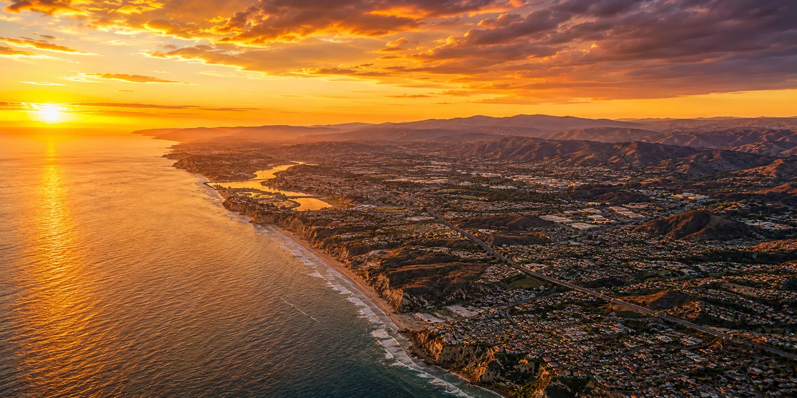 The San Diego County coastline at sunset, with hills rising inland.