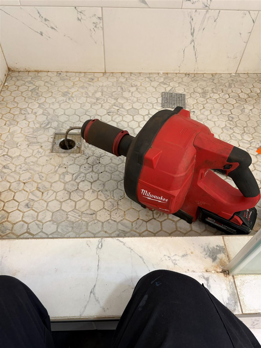 Clearing a clogged shower drain.