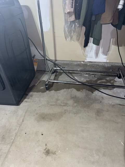 Water across a garage floor during a slab leak investigation.